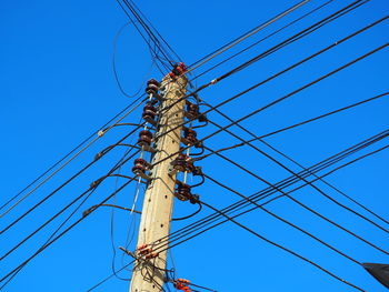 Low angle view of cables against blue sky