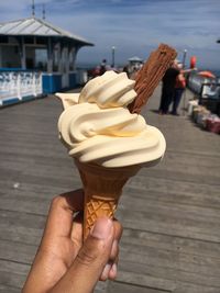 Cropped hand holding ice cream cone in city