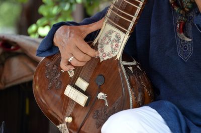 Midsection of man playing sitar