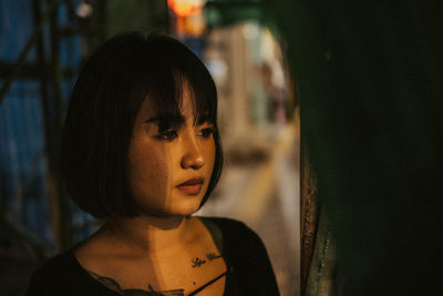 Close-up portrait of young woman looking away