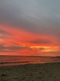 Scenic view of sea against dramatic sky during sunset