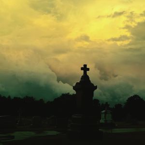 Silhouette of church against cloudy sky