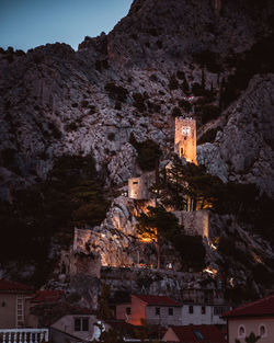 Low angle view of illuminated buildings against mountain