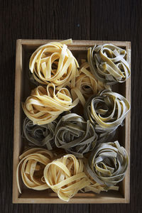 Directly above shot of tagliatelle pasta in crate on table