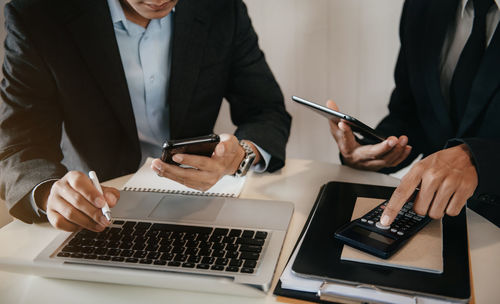 Midsection of business colleagues working at office