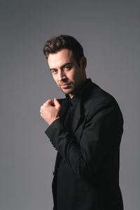 Young man looking away against gray background