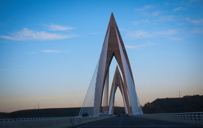 Low angle view of suspension bridge against sky during sunset