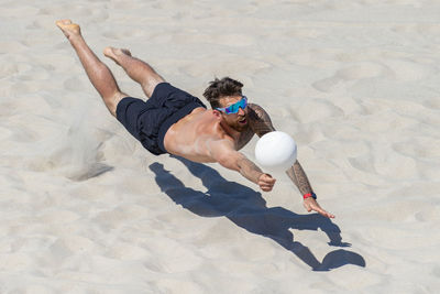 High angle view of man playing with ball on sand