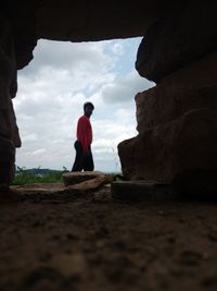 Rear view of man on rock against sky