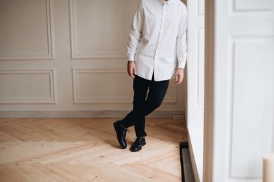 Low section of man standing on floor at home