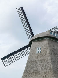 Low angle view of traditional windmill against sky