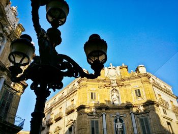 Low angle view of street light against blue sky