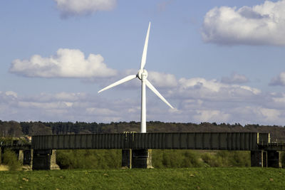 Windmill on field against sky