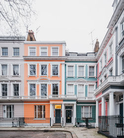 Residential buildings by street against sky