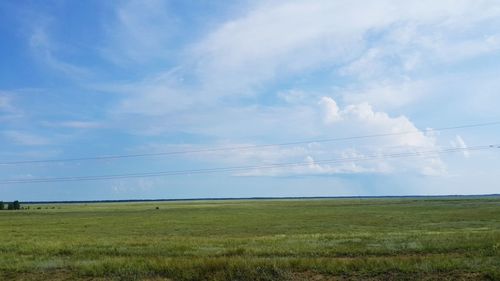 Scenic view of field against cloudy sky