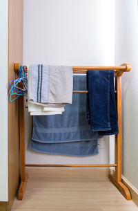 The wooden clothesline with the towel and jeans and shorts.