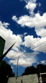 Low angle view of power lines against cloudy sky