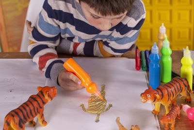 Boy painting a tiger at home.