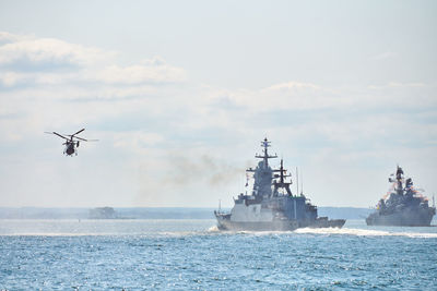 Battleships war ships corvette during naval exercises and helicopter maneuvering over sea waters