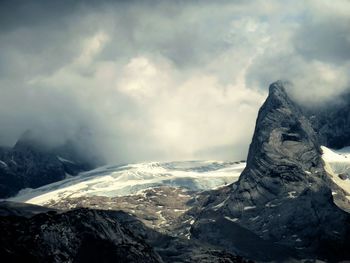 Scenic view of mountains against cloudy sky