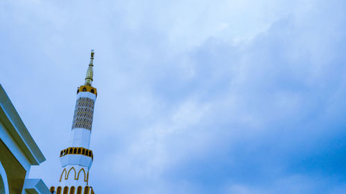 Low angle view of lighthouse against buildings