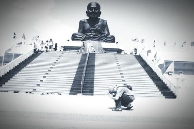 Statue on steps against sky