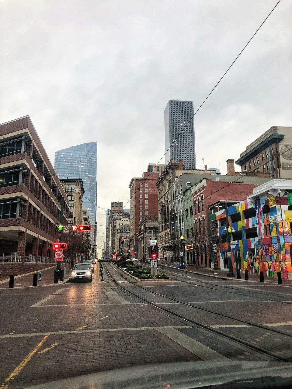 CITY STREET AMIDST BUILDINGS AGAINST SKY