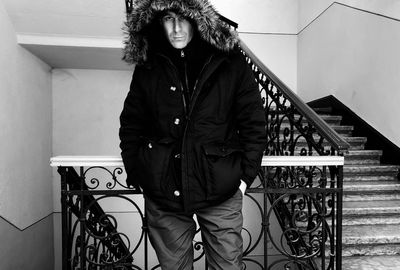 Portrait of man standing against railing in winter