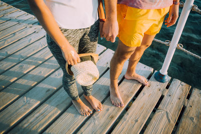 Low section of woman standing on wooden pier