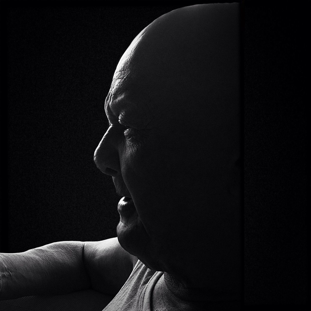 headshot, close-up, lifestyles, head and shoulders, human face, leisure activity, black background, studio shot, person, indoors, serious, part of, contemplation, front view, holding, focus on foreground