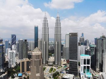 Modern buildings in city against cloudy sky