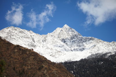 Low angle view of snowcapped mountains against sky