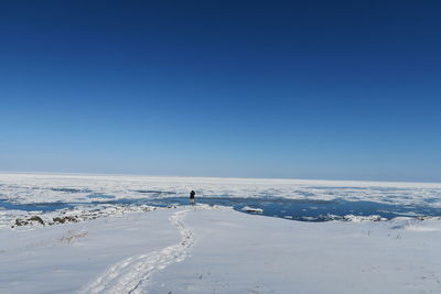 Scenic view of snowcapped landscape against clear blue sky