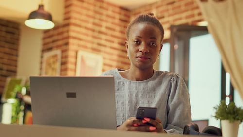 Portrait of young woman using mobile phone at home