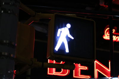 Low angle view of illuminated sign at night