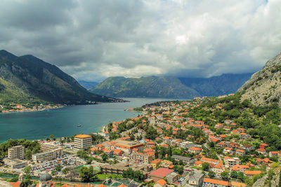 Town by sea and mountains against sky