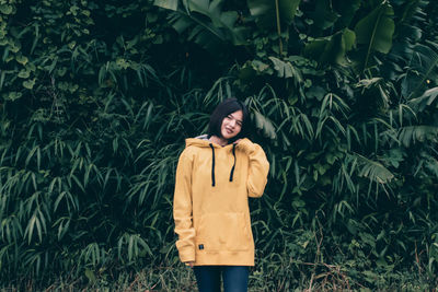 Young woman standing by plants
