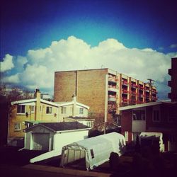 Buildings against cloudy sky