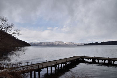 Scenic view of lake by snowcapped mountain against sky