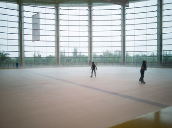 Full length of people practicing ice skating