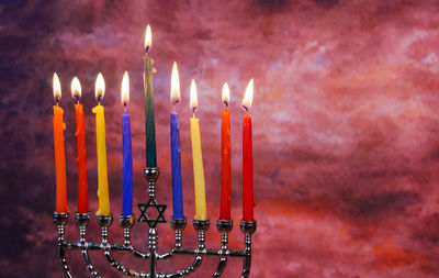 Close-up of illuminated candles against wall