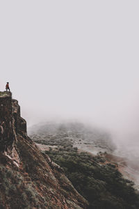 Woman standing on mountains against sky