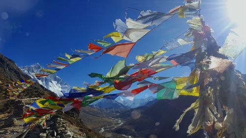 Low angle view of multi colored flags on mountain against sky