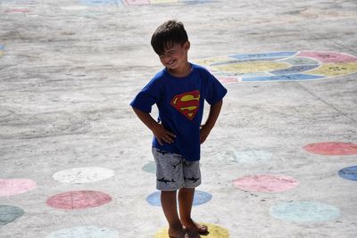 Full length of boy standing on yellow spot at concrete ground