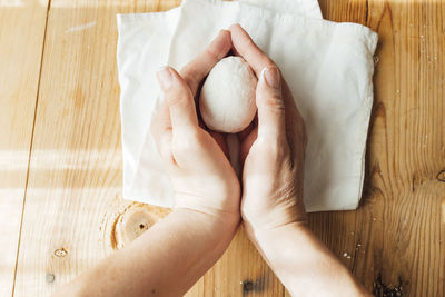 Midsection of woman holding heart shape on table