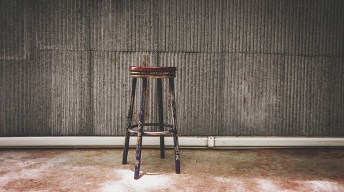 Vintage chair with galvanized wall and concrete floor background. copy space.