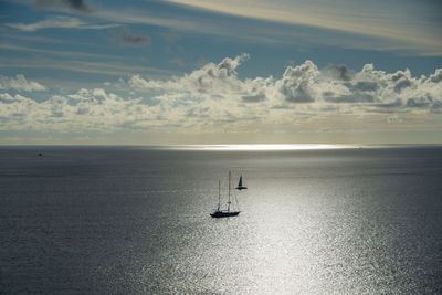 Sailboat sailing on sea against sky