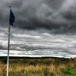 Scenic view of field against cloudy sky