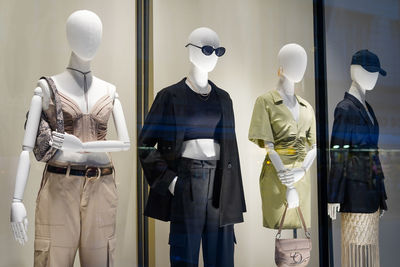 Four mannequins in stylish clothes shop window