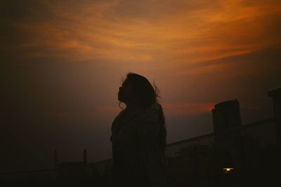 Silhouette man standing against sky during sunset